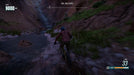 Action-packed Riders Republic Complete Edition screenshot on PC, showing intense mountain biking through a riverbed at Zion Falls Cliffs. Purchase your Ubisoft activation key at RushGame.co