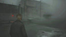 SILENT HILL 2 gameplay on Steam displaying the main character in a foggy, abandoned street with eerie lighting—buy your Steam key at RushGame.co and step into the haunting world of Silent Hill with fast digital delivery.