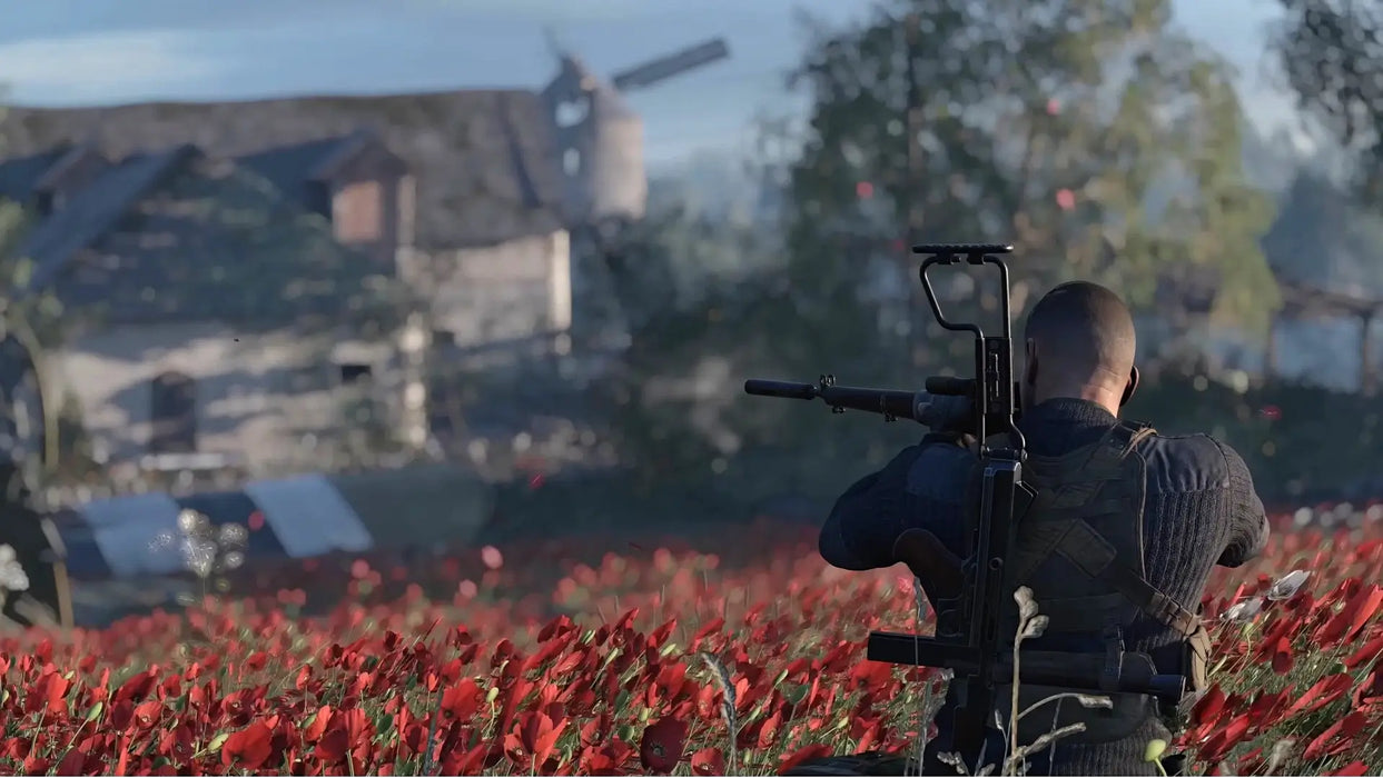 Sniper Elite 5 Complete Edition Xbox One gameplay with the protagonist aiming from a field of red poppies toward distant buildings. Get your Xbox One key instantly at RushGame.co
